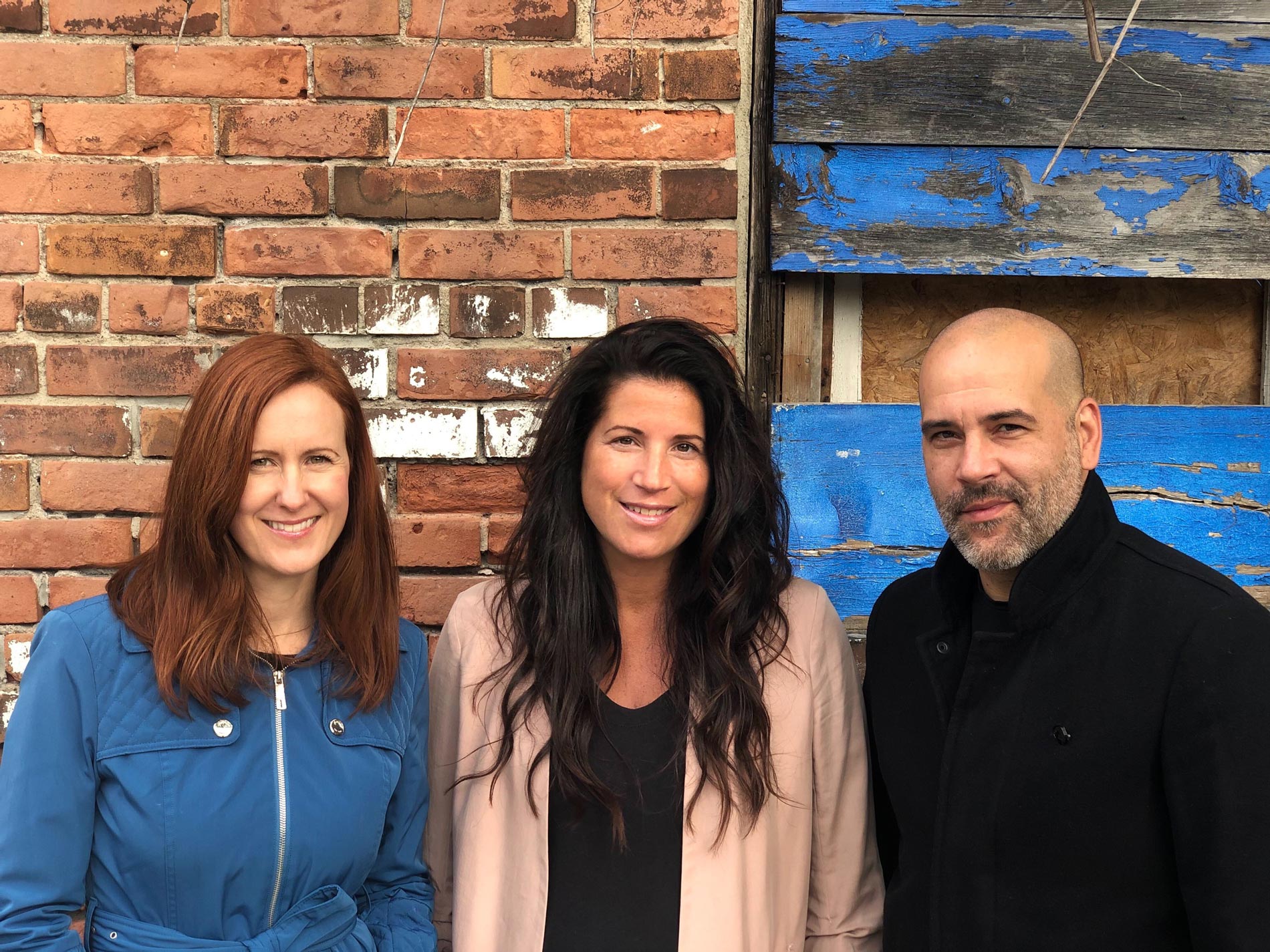 The We Know Houses team in front of a brick wall in Toronto